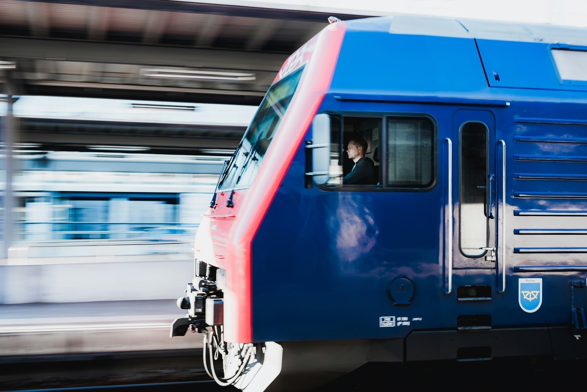 A train driver at the controls of a UK passenger train